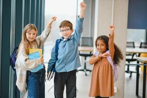 gruppo di elementare scuola bambini nel un' scuola corridoio foto