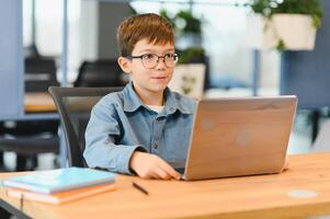 allegro ragazzo studiando computer nel bellissimo stile. in linea formazione foto