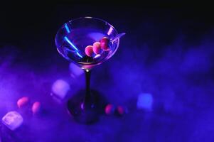 Martini cocktail bevanda spruzzo con ghiaccio cubi nel neon iridescente rosa e blu colori. minimo notte festa vita concetto. foto