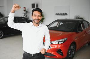 indiano uomo adulto cliente maschio acquirente cliente indossa classico completo da uomo bianca camicia sceglie auto vuole per acquistare nuovo automobile toccare dai un'occhiata auto nel showroom veicolo salone concessionaria memorizzare il motore mostrare interno. foto