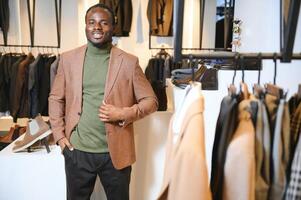 giovane africano uomo shopping nel capi di abbigliamento memorizzare foto