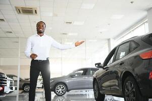 ritratto di bello africano americano venditore a posto di lavoro nel auto showroom foto