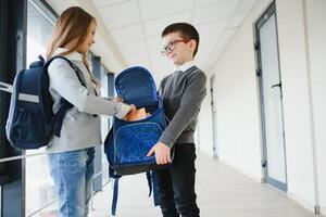 scuola bambini nel uniforme insieme nel corridoio. concezione di formazione scolastica foto