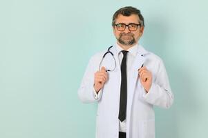 professionale medico uomo nel bianca uniforme in posa su blu studio sfondo. panorama con copia spazio. foto