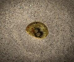 bitcoin sepolto nel il sabbia foto