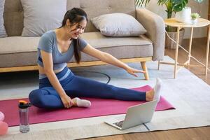 donne siamo allungamento, a casa, e fitness donne esercizio o fare yoga nel loro Camera da letto per Salute e benessere un' sano, calma femmina persona formazione o Lavorando su il Casa pavimento. foto