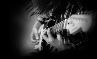 un' giovane uomo giochi il elettrico chitarra foto