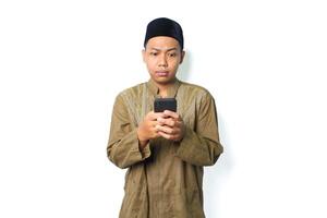 confuso asiatico musulmano uomo leggere Messaggio utilizzando smartphone mostrare pensiero espressione isolato su bianca sfondo foto