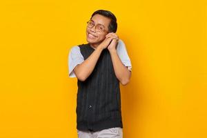 ritratto di allegro giovane uomo asiatico con il braccio vicino all'orecchio felicissimo isolato su sfondo giallo
