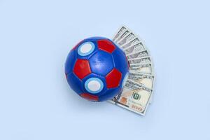 un' calcio palla con i soldi su un' blu sfondo foto