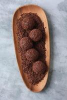 Brigadeiro o brigadiere, tradizionale brasiliano dolce dolce. cioccolato caramella su di legno piatto foto