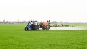 trattore con un' spray dispositivo per finemente disperso fertilizzante. foto