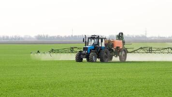 trattore con un' spray dispositivo per finemente disperso fertilizzante. foto