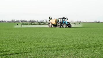 trattore con un' spray dispositivo per finemente disperso fertilizzante. foto