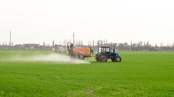 trattore con un' spray dispositivo per finemente disperso fertilizzante. foto