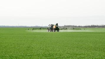 trattore con un' spray dispositivo per finemente disperso fertilizzante. foto