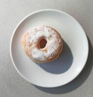 foto di bianca in polvere zucchero ciambelle su un' piatto pronto per mangiare