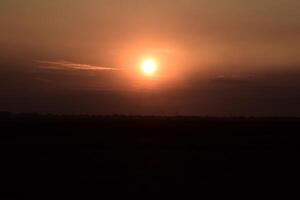 trattore aratura aratro il campo su un' sfondo tramonto. trattore silhouette su tramonto sfondo foto