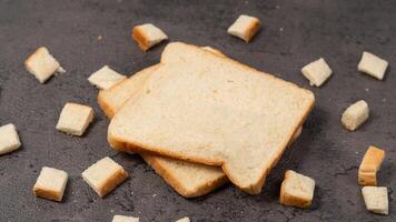 affettato pane isolato su grigio sfondo. pane tagliare in piccolo piazze foto