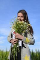 giovane bellissimo ragazza con un' mazzo di camomilla. un' donna nel un' foto