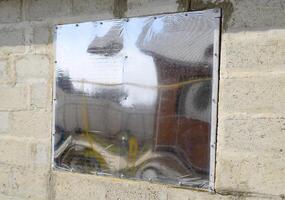 un' finestra fatto di plexiglas nel un' calcestruzzo parete. un' finestra con un' riflessivo etichetta. foto