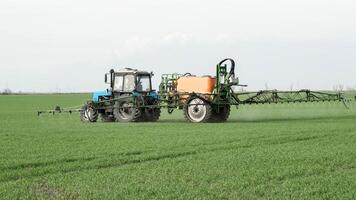 trattore con un' spray dispositivo per finemente disperso fertilizzante. foto