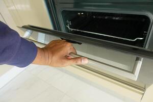 mano Aperto elettrico forno porta a casa foto