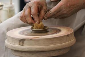 mani di un vasaio, creando un vaso di terracotta sul cerchio foto