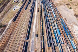 carico treni. aereo Visualizza di colorato nolo treni su il ferrovia stazione. carri con merce su ferrovia.aereo Visualizza foto