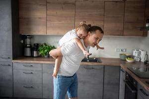 un' contento padre e poco ragazza con gioia la spesa tempo nel un' moderno cucina. contento famiglia. Il padre di giorno. foto