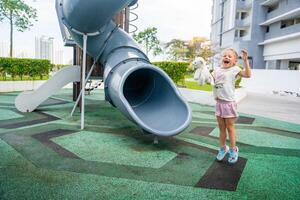 contento poco ragazza su terreno di gioco su tetto di uno di edificio nel giorgio, Malaysia, concetto per divertimento e sicurezza di bambini. foto