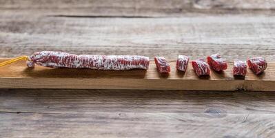 tagliare spagnolo salame su il di legno tavola foto