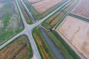 incrocio stradale pavimentata strade attraverso il campi. Visualizza a partire dal sopra foto