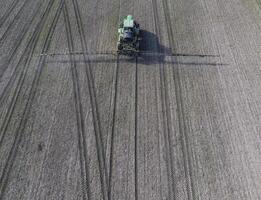 trattore con incernierato sistema di spruzzatura pesticidi. fertilizzante con un' trattore, nel il modulo di un aerosol, su il campo di inverno Grano. foto