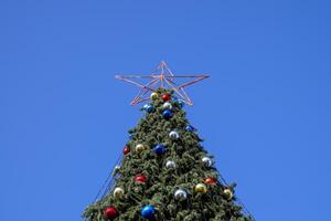 decorazioni nuovo anno albero. orpello e giocattoli, palle e altro decorazioni su il Natale Natale albero in piedi nel il Aperto aria. foto