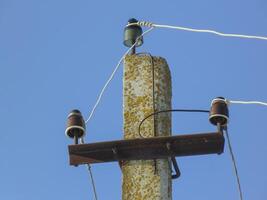 elettrico colonna. elettrico colonna con fili durante un' declino contro il chiaro blu cielo. foto