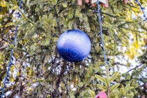 decorazioni nuovo anno albero. orpello e giocattoli, palle e altro decorazioni su il Natale Natale albero in piedi nel il Aperto aria. foto