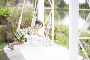 un' giovane donna si siede su un' swing e ammira il mozzafiato Visualizza di bellissimo natura. foto