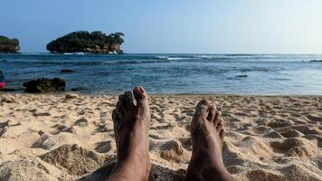 seduta su il spiaggia godendo il bellissimo oceano paesaggio foto