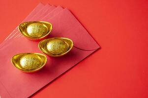 d'oro lingotto su superiore di rosso pacchetti. Cinese nuovo anno celebrazione concetto foto