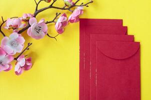 superiore Visualizza di Cinese nuovo anno rosso pacchetto e ciliegia fiorire decorazione con personalizzabile spazio per testo o auguri. Cinese nuovo anno celebrazione concetto. foto