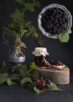 un' vaso di mora marmellata e bruschette con morbido formaggio e frutti di bosco foto