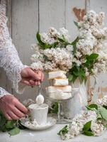 donna preparazione un' freddo caffè dolce, primavera ancora vita nel retrò stile, un' pila di cialda ghiaccio crema nel un' ciotola foto