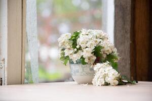 piccolo mazzo di ramo di un' fioritura biancospino nel vaso su vecchio squallido finestra davanzale, romantico umore e primavera freschezza foto