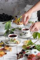 donna mano si agita zucchero nel porcellana retrò tazza di frutta Tè, un' colino pieno di maturo more, Vintage ▾ ancora vita foto