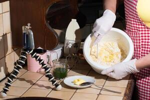donna cucinando spinaci muffin passo di fare un passo, miscelazione ingredienti con spatola foto