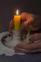 un' illuminato candela fra Da donna palme nel il buio silenzio e condoglianze, foto