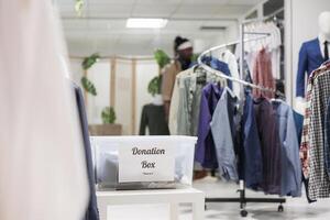 donazione scatola pieno con Usato capi di abbigliamento per beneficenza nel shopping centro commerciale boutique. contenitore con secondo mano abbigliamento per umanitario aiuto nel moda indumento negozio con no persone dentro foto