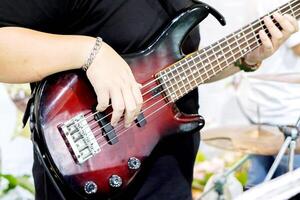 avvicinamento di del musicista mani giocando elettrico chitarra su sfocato sfondo. foto