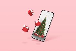 telefono con albero di natale e regali che escono dal display. concetto minimale con colore rosa pastello sullo sfondo foto